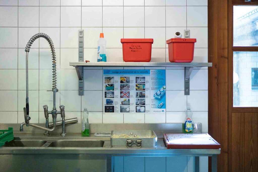 Modern eco-friendly kitchen with organized fridge and green cleaning supplies.
