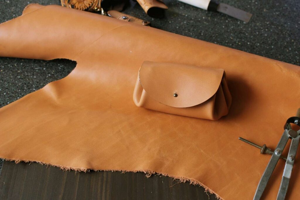 Homemade leather conditioner being applied on a brown leather couch with a cloth