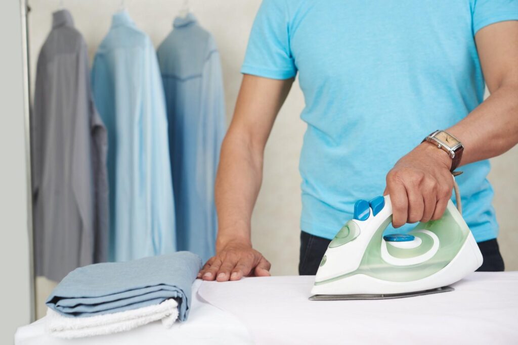 Side-by-side comparison of steam iron and garment steamer on table